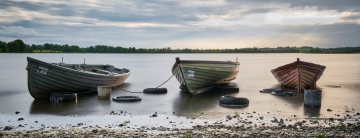 Three boats on a calm lake in Ireland.  Photo by Daniel Kane Photography.
